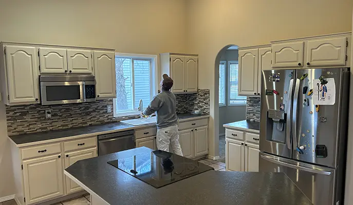 painter inspects kitchen after interior painting