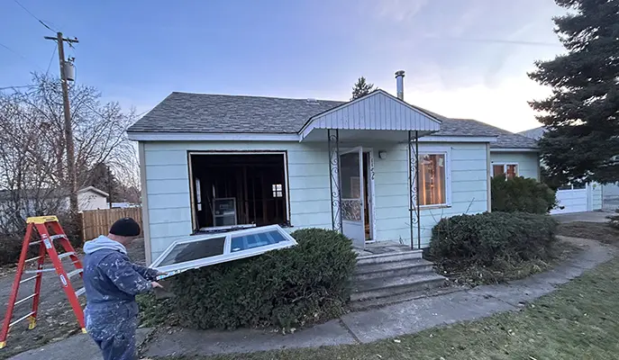 worker replaces windows in house