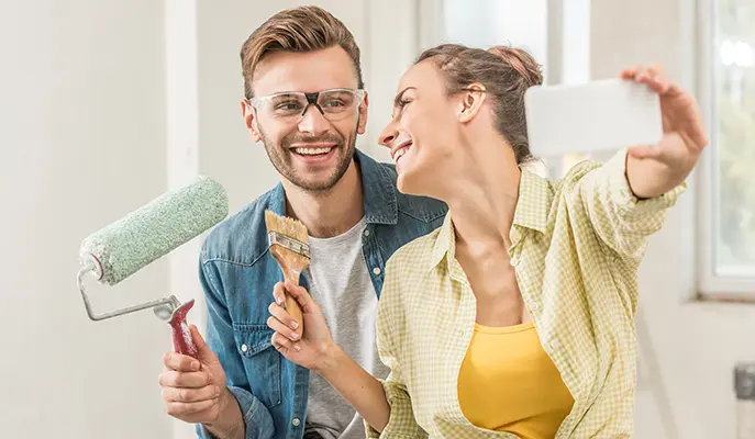 happy couple painting the interior of their home