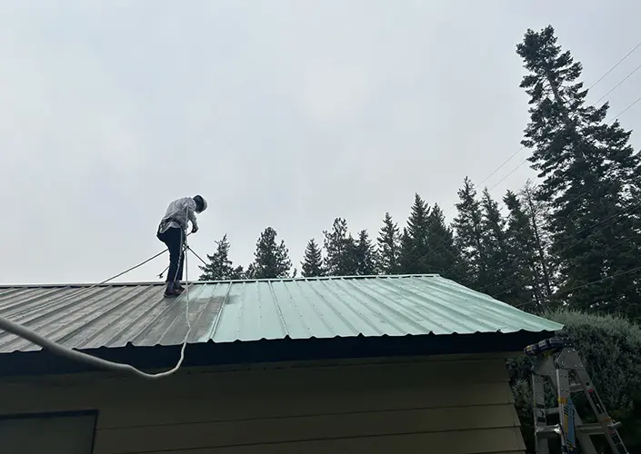 a painter applies paint to a roof