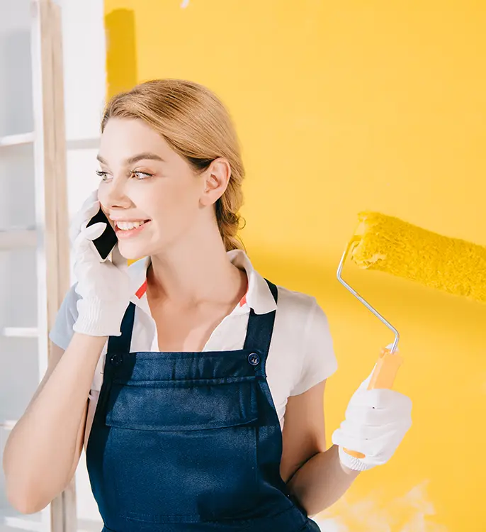 happy painter in uniform calling on the phone