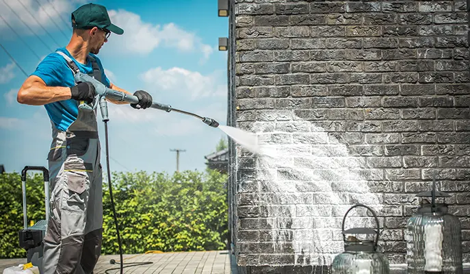 cleaning the facade of the house with a high pressure washer