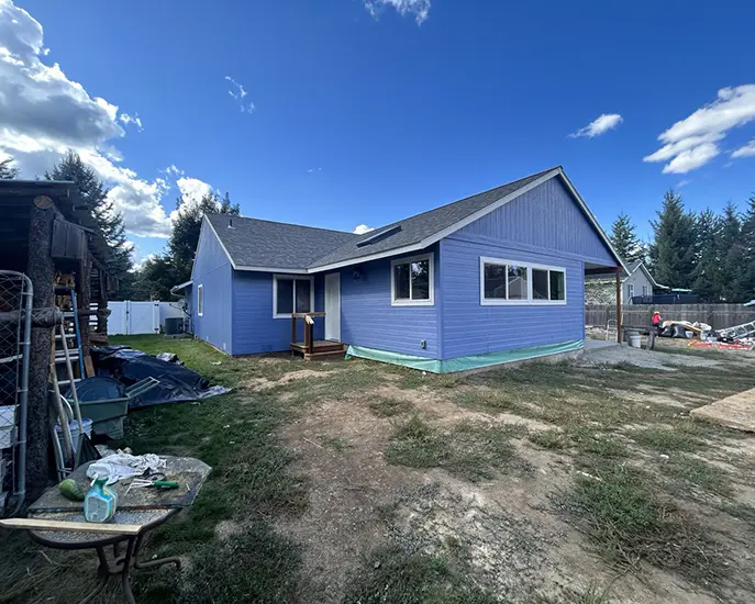 blue house after exterior house painting and roof cleaning