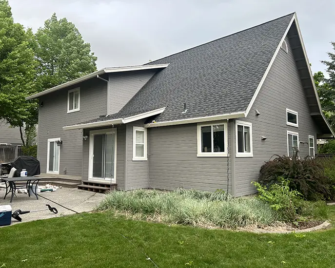 finished result of exterior painting of house in grey color and cleaned roof