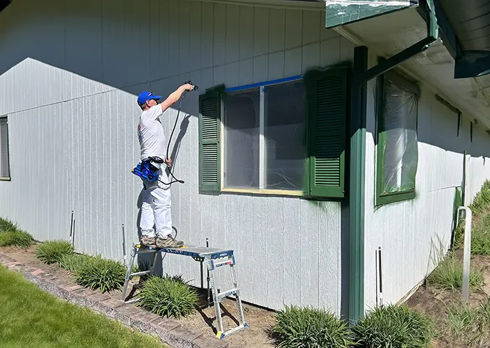 a painter paints the exterior of a house