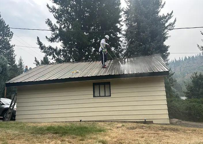 a painter cleans the roof of a house